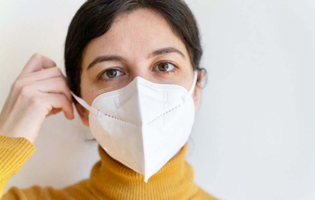 woman putting on a mask