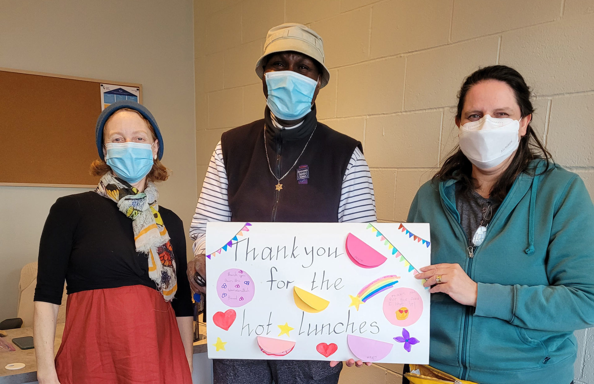 people holding a sign saying thank you for the hot lunches