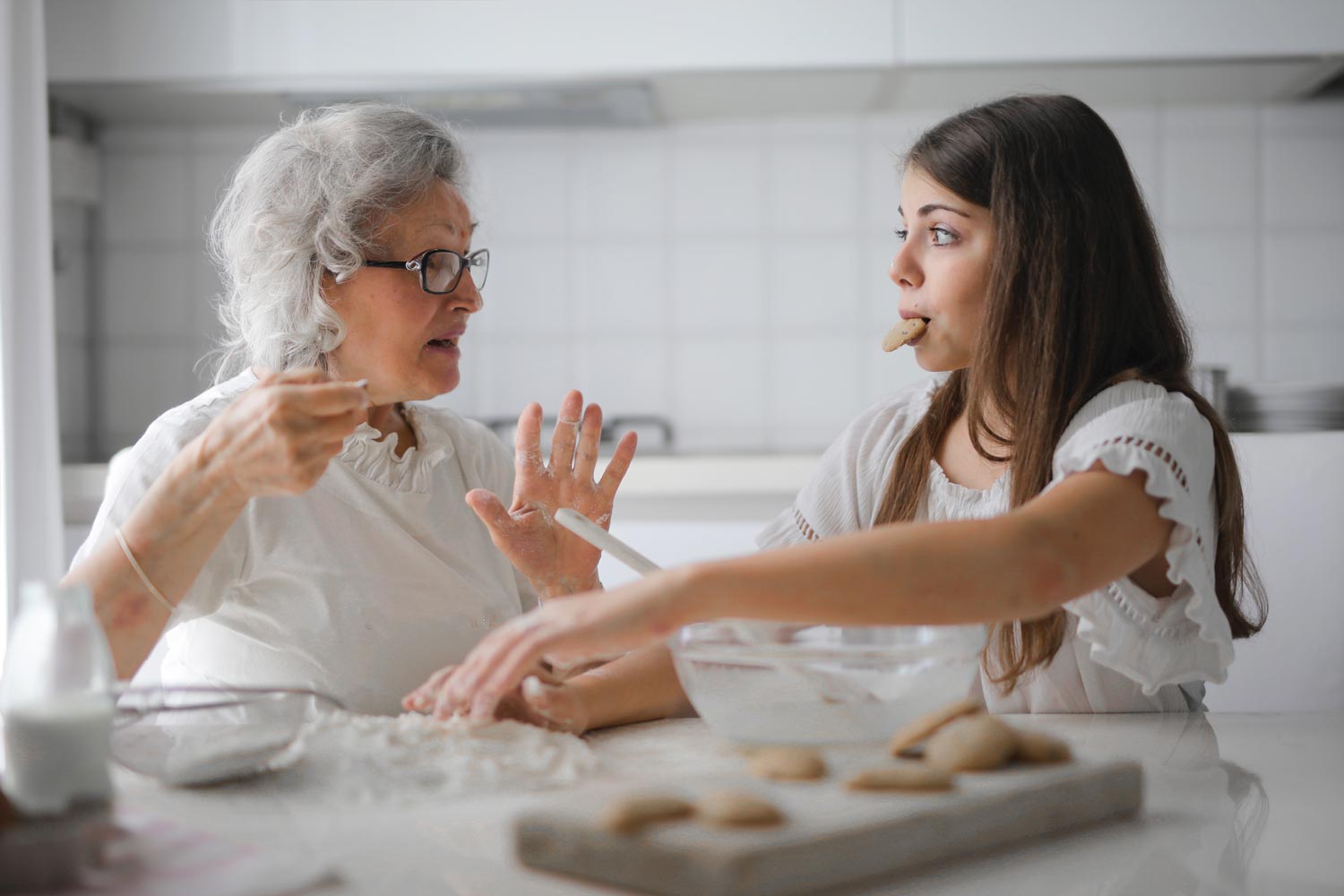 grandma and child making and eating cookies